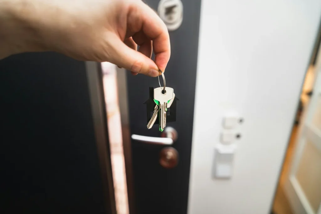 Person holding a key to a door, representing a mortgage product switch to a new rate