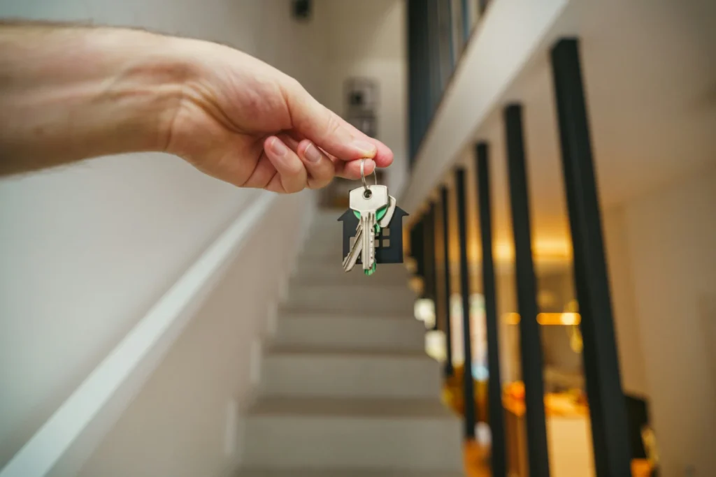 Hand holding keys with a house keychain, representing renewing your mortgage and keeping your home