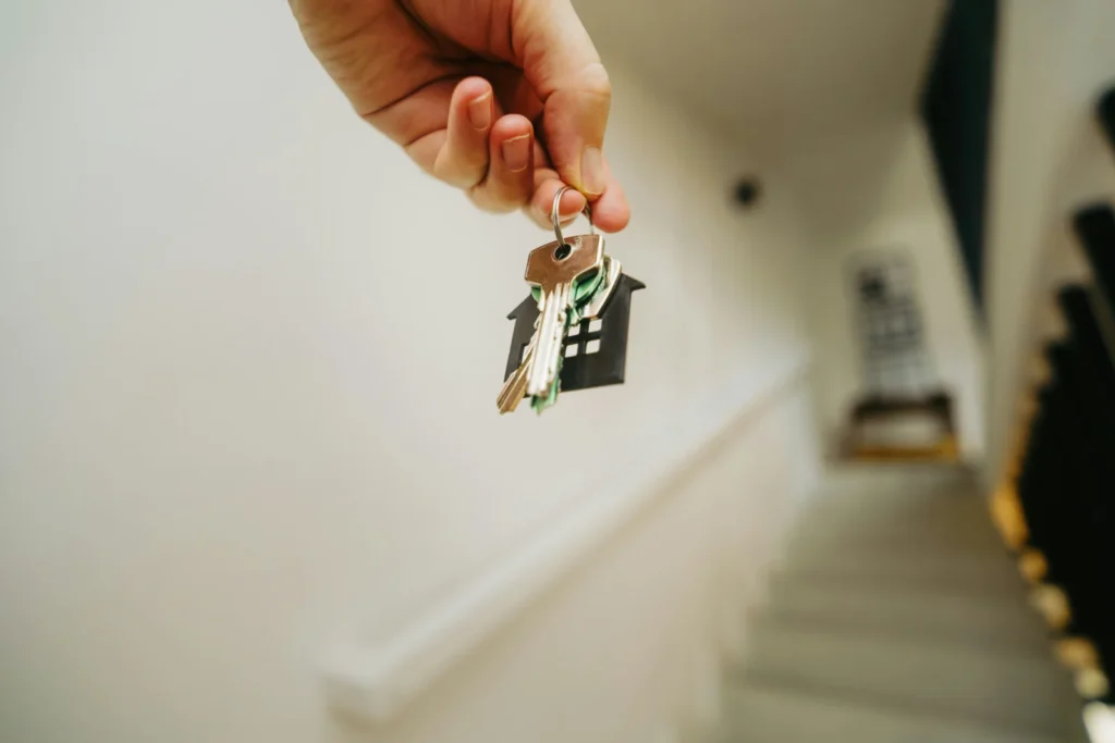 Person holding a house key, representing switching mortgage deal with the same lender and staying in your home